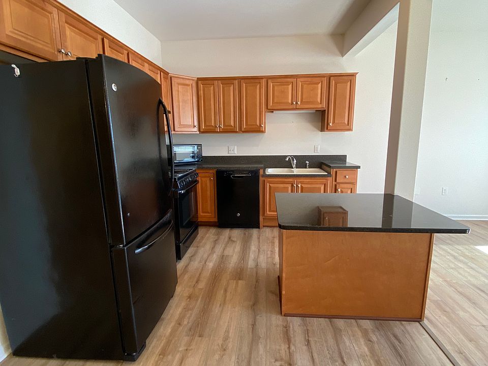 Open kitchen with lower countertop island and sink area to accommodate for roll-up access