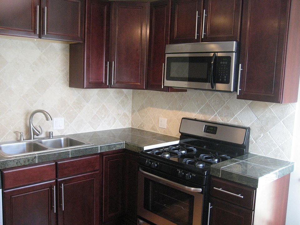 Kitchen with granite counter tops, stone backsplash and stainless steel appliances
