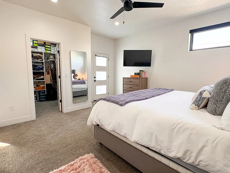 3rd floor primary bedroom with walk in closet and door to access private balcony that overlooks the valley.