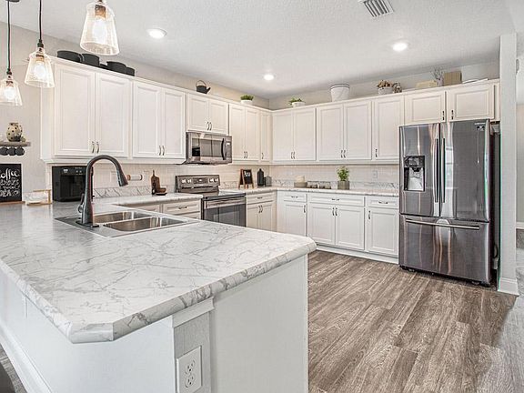 Enjoy an open kitchen with 36-in. cabinets, Samsung SS appliances, and a large double-door pantry -