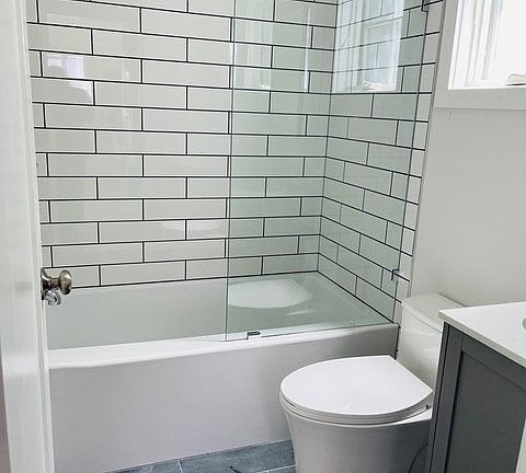 Bathroom with tub and shower, storage cabinet, drawer and mirror cabinet and high screened window that opens