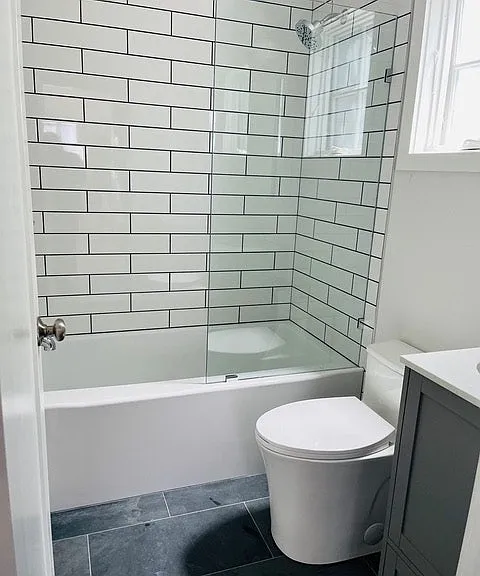 Bathroom with tub and shower, storage cabinet, drawer and mirror cabinet and high screened window that opens