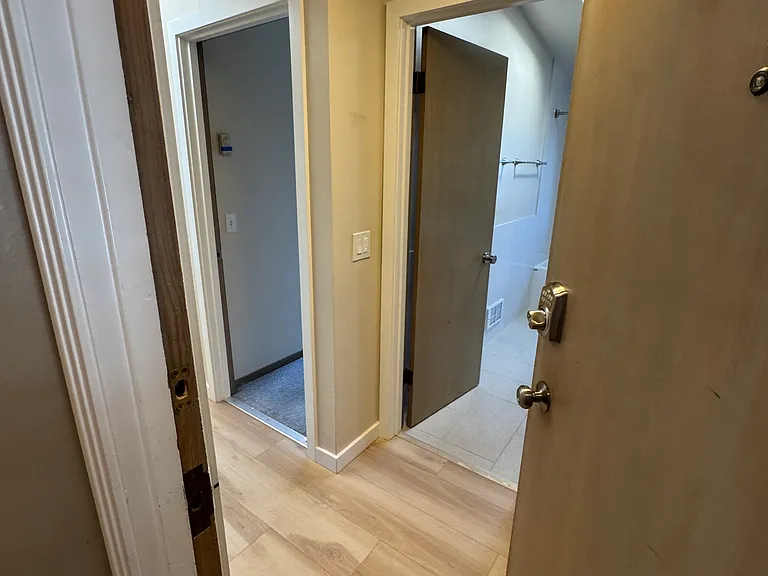 Walking into the apartment from the back door. Looking into first bedroom and bathroom.