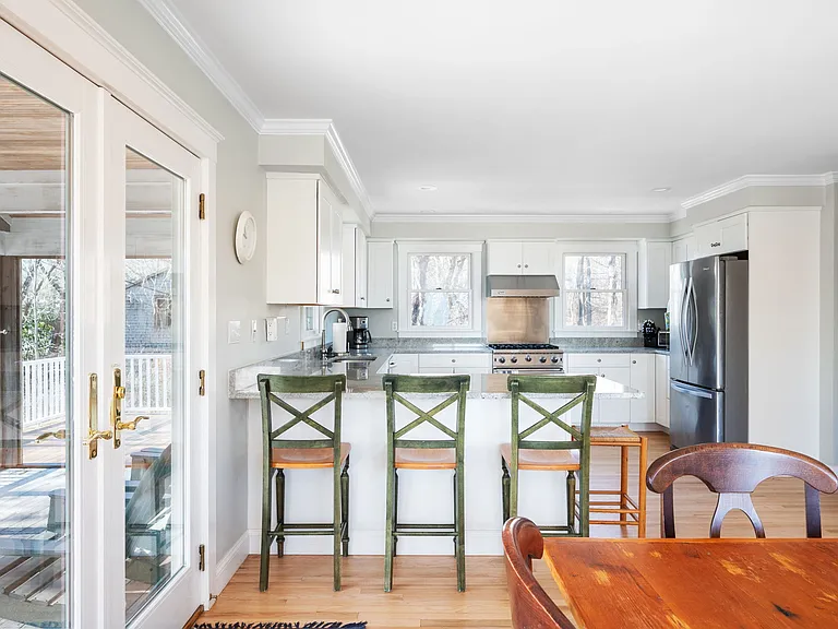 View from dining area to kitchen with bar seating, Viking stove, and all the kitchen items you'll need.