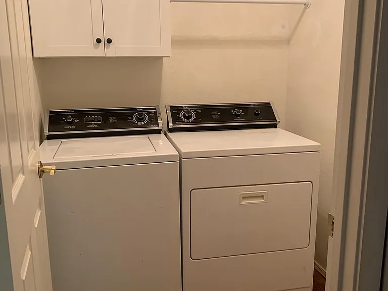 Separate laundry room with new washer/dryer, cabinets and hanger bar.