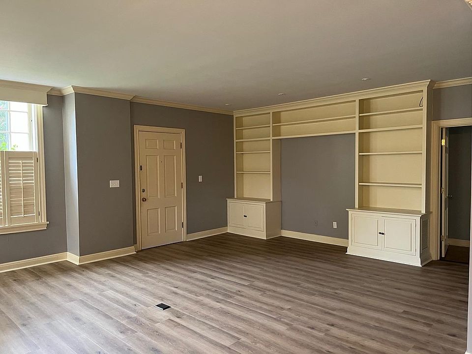 Living room has a huge built-in bookcase with cabinets