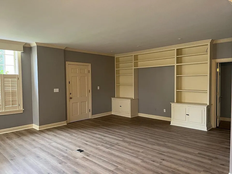 Living room has a huge built-in bookcase with cabinets