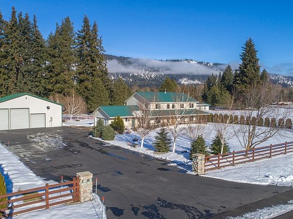 Fully fenced acreage, paved driveway, and a gated entrance.