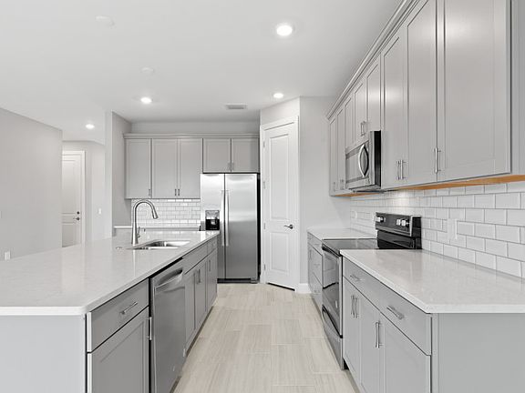 Stainless steel appliances and stylish kitchen backsplash