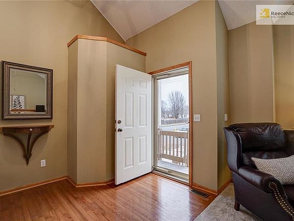 Entry w inviting storm door, vaulted ceiling and hardwood floors.