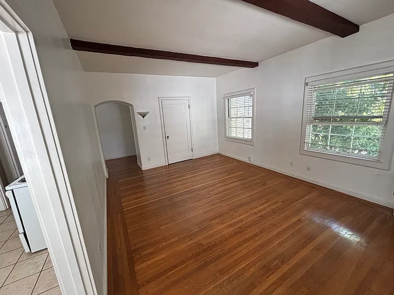 Living room with real hardwood and high, beamed ceilings