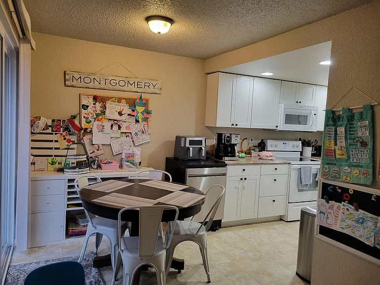 Nook/dining room is just off the kitchen. There is a sliding glass door to the right of the table that leads to the fully fenced backyard and large patio.