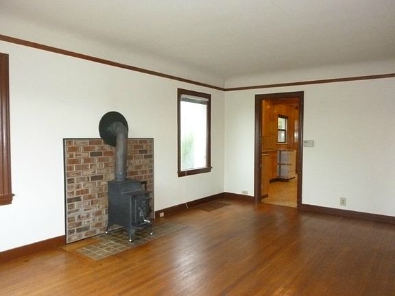 Wood burning fireplace in living room (not certified) and exposed oak hardwood floors.