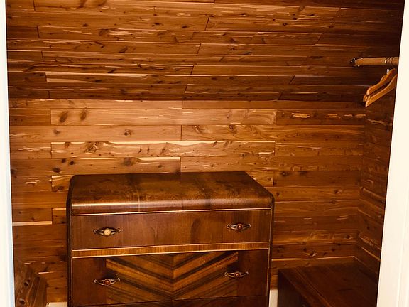Cedar-lined closet with clothing racks on each side & bureau