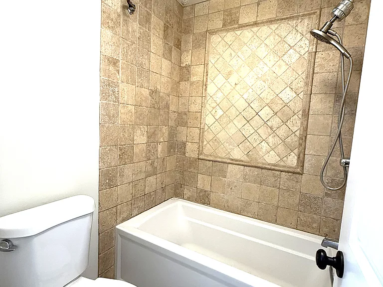 Bath 2 tub/shower with travertine surround.