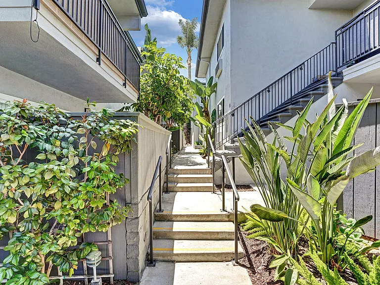 A staircase with a metal railing leads up to a balcony.