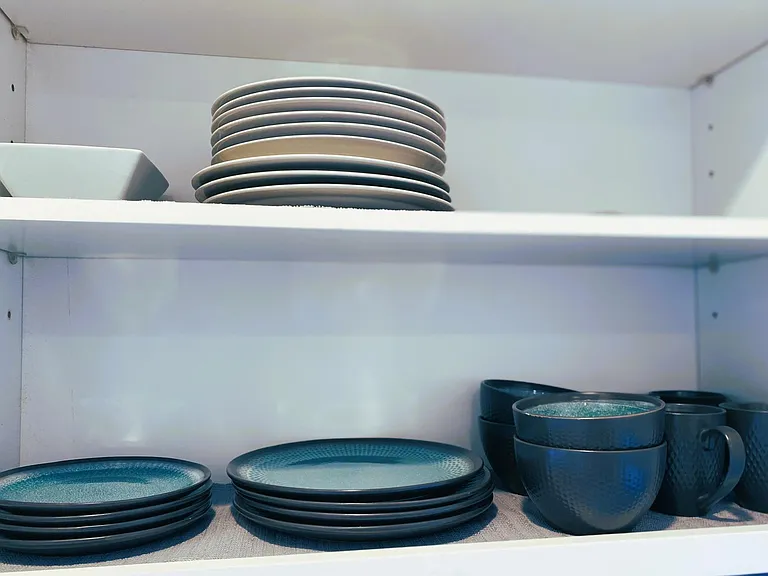 Kitchen stocked with all plates, utensils, pots, and pans