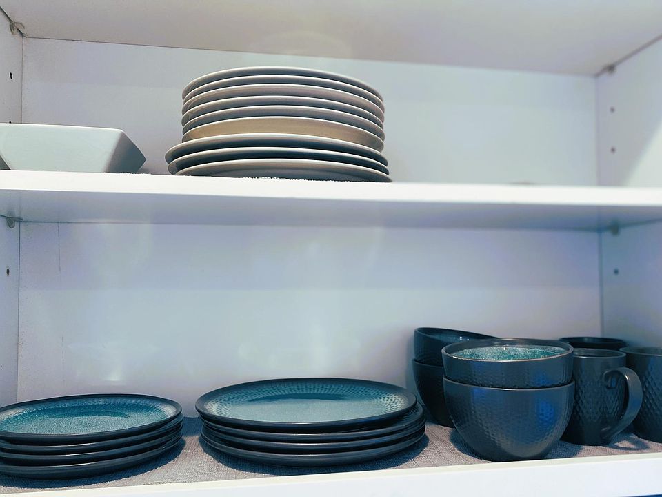 Kitchen stocked with all plates, utensils, pots, and pans