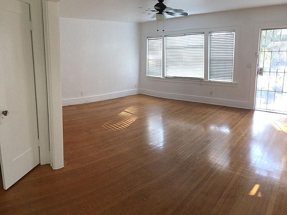 The spacious main room features ample windows and a ceiling fan.
