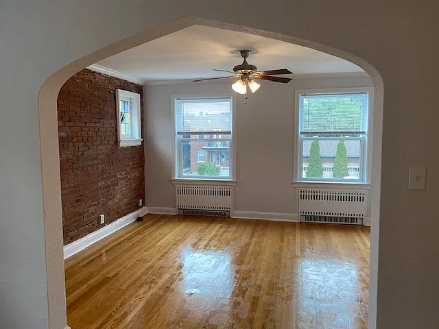 Large, light living room with stained glass and exposed brick