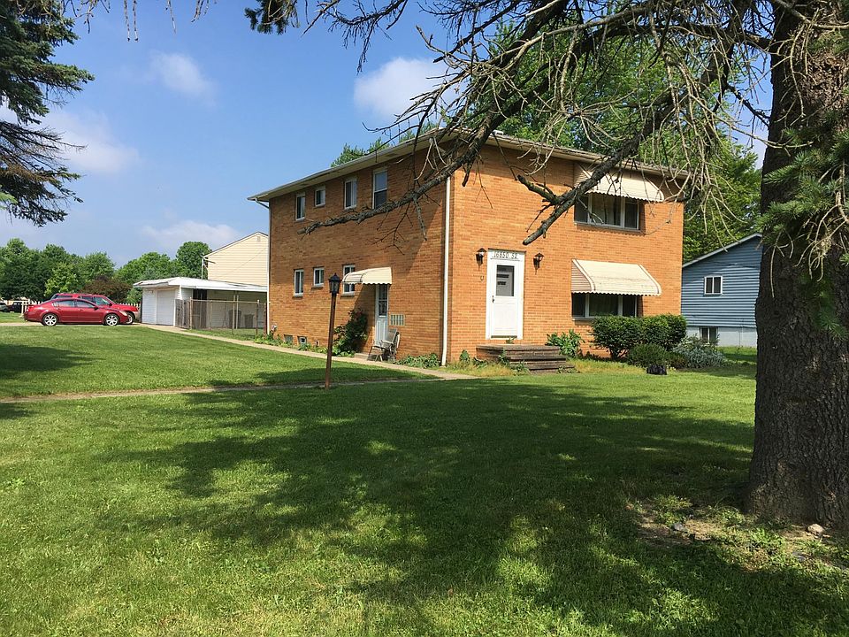 Two car garage on left shared with other tenant. One garage space for each apartment plus an area of shared common space. Upper tenant's entrance is three steps up on the right without an awning.