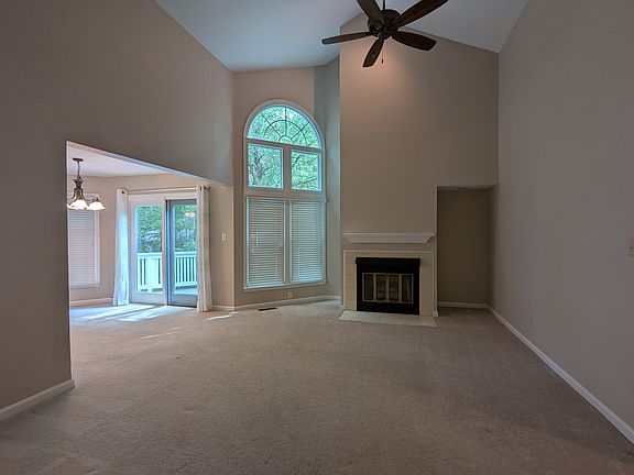 Entry into living room with vaulted high ceilings. Door to deck and dining area.