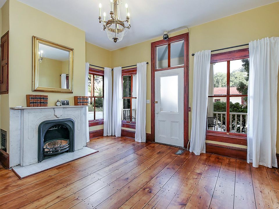 Front room with separate entrance and half bath for home office or bedroom. Original hardwood floors, high ceilings with natural light, period chandeliers, marble fireplace.