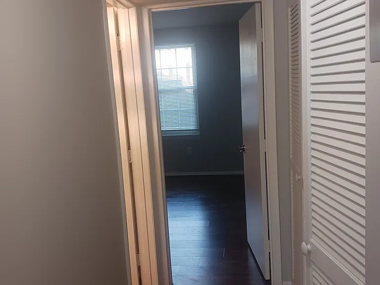 Hallway to second bathroom and sunny second bedroom which is 12x11 with 6-foot closet.