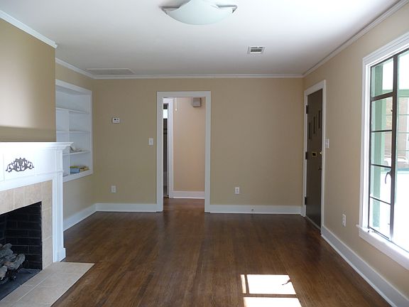 Spacious living room includes elegant mantle and built-in bookcase