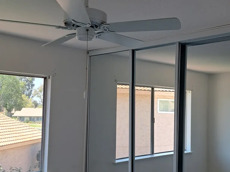 Upstairs Bedroom 2 with ceiling fans and mirror doors