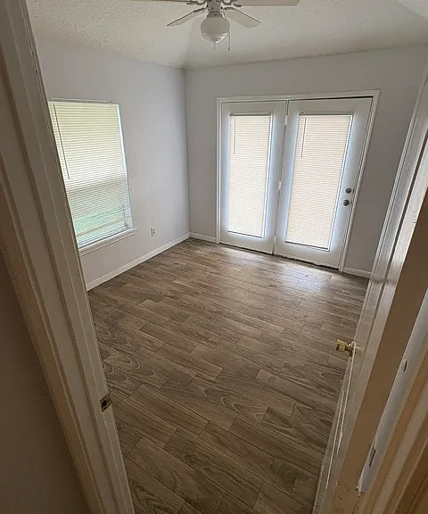master bedroom with exit to backyard. new tiled floors and ceiling fan.