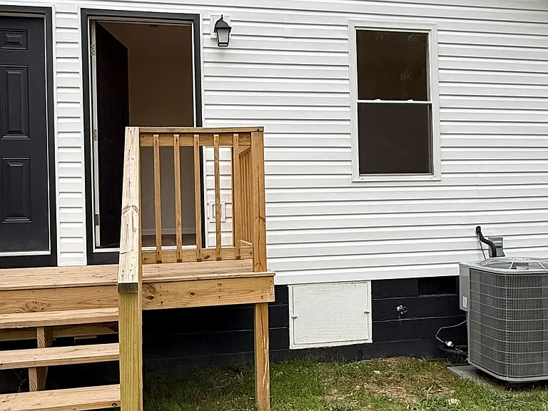 Large fenced backyard with an expansive lawn and plenty of room for outdoor activities, relaxing, gardening, or entertaining. Private rear entrance with a dedicated wooden deck and steps provides convenient access to the backyard.