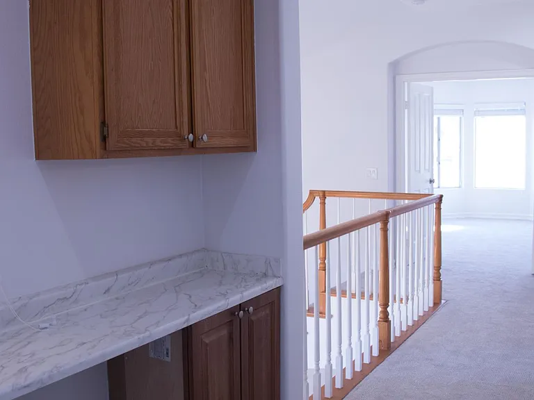 Upstairs hallway storage with newly installed cabinet and granite counter top