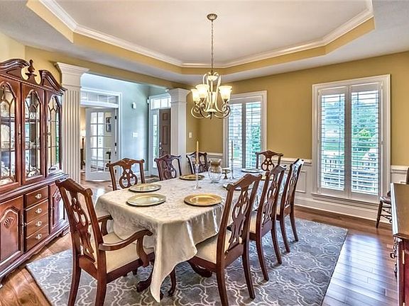 Elegant Dining Room topped with a tray ceiling, wainscoting, fluted columns!