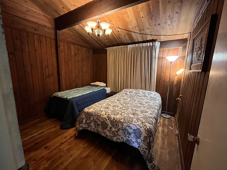 Rustic cedar cabin guest bedroom includes a full bed and twin bed to accommodate visiting family and friends.