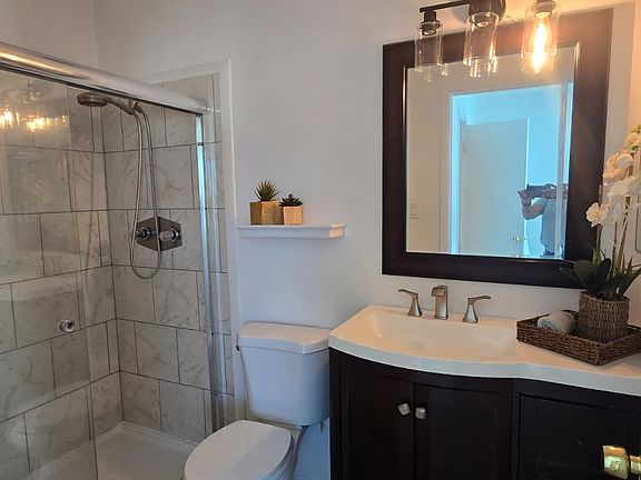 Primary full bathroom with tiled shower and new lightly.