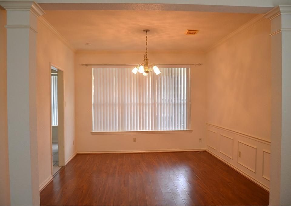 Formal dining room with chair rails and laminate floor.
