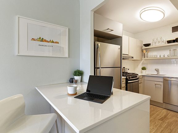 Open kitchen with stainless steel appliances and quartz countertops