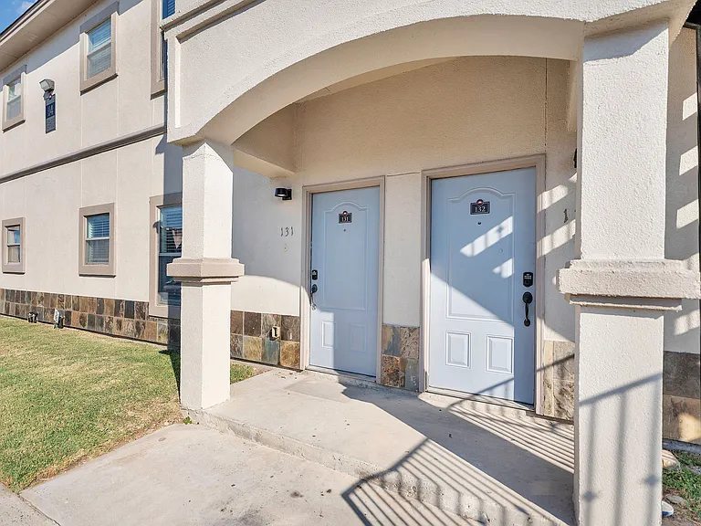 Sophisticated entrance to Merida Vista Apartments in Laredo, Texas, showcasing two doors and a refined exterior design