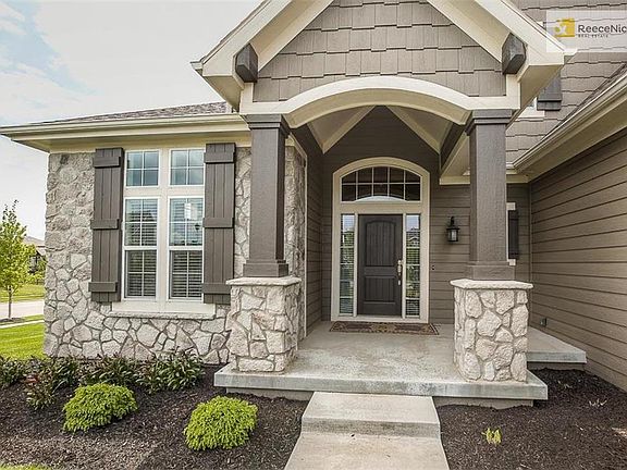 Covered front porch with lush landscaping