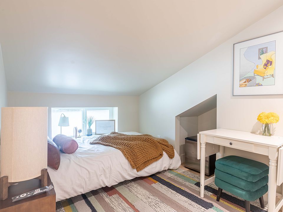 95 sq ft slope ceiling room. Small fridge. Smart TV, Small Table & Chair.