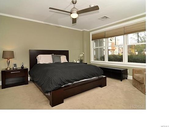 Large master bedroom with custom blinds and high end ceiling fan