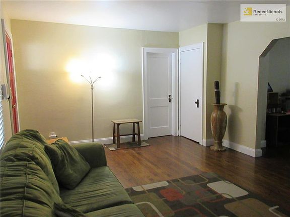 Living Room with wood floor and notice the arched doorway into the dining room