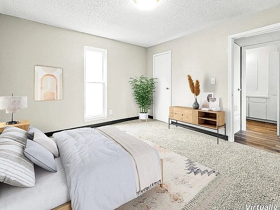 Bright and cozy bedroom with plush carpeting, modern furnishings, and a serene ambiance, showcasing virtual staging.