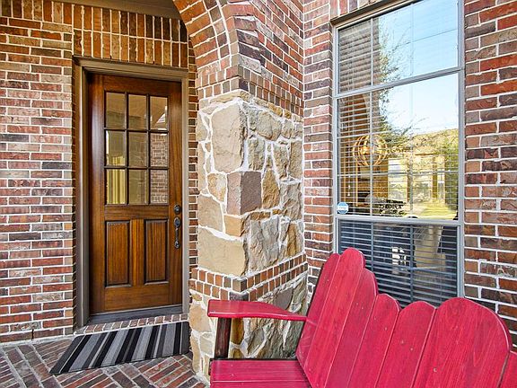 The front door is tucked away to the left at the end of the entryway, leaving a more secure front porch and front door. This inner porch is secluded under a beautiful brick arch. This more secluded inner porch creates a great space for package delive
