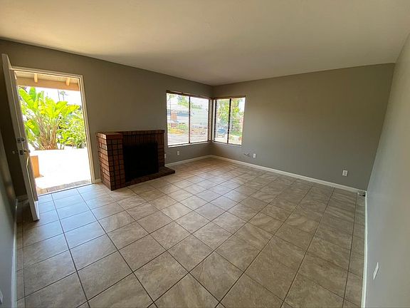 Living room. Front door is open to deck. Blinds are now white (see picture with two chairs)
