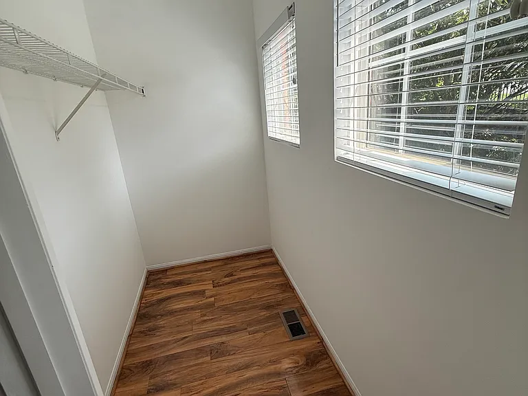 A bright, oversized walk-in closet with abundant storage and natural light to keep your wardrobe organized.