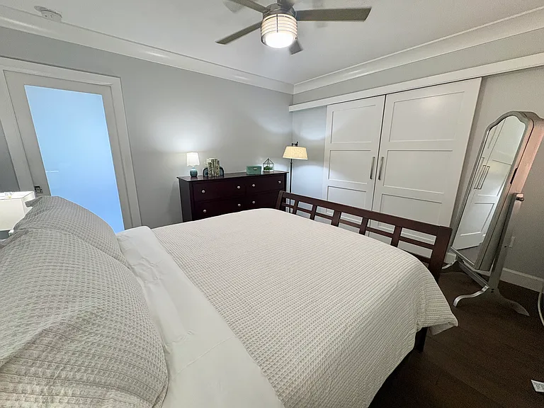 Frosted glass sliding door to bedroom allows natural light throughout apartment. New ceiling fans with remotes. Second air conditioner unit bedroom.