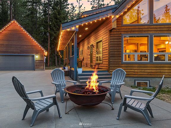 Newly poured concrete pad extends from the pavement to the garage and adds patio/firepit space. There are also newly poured concrete steps leading to the deck.