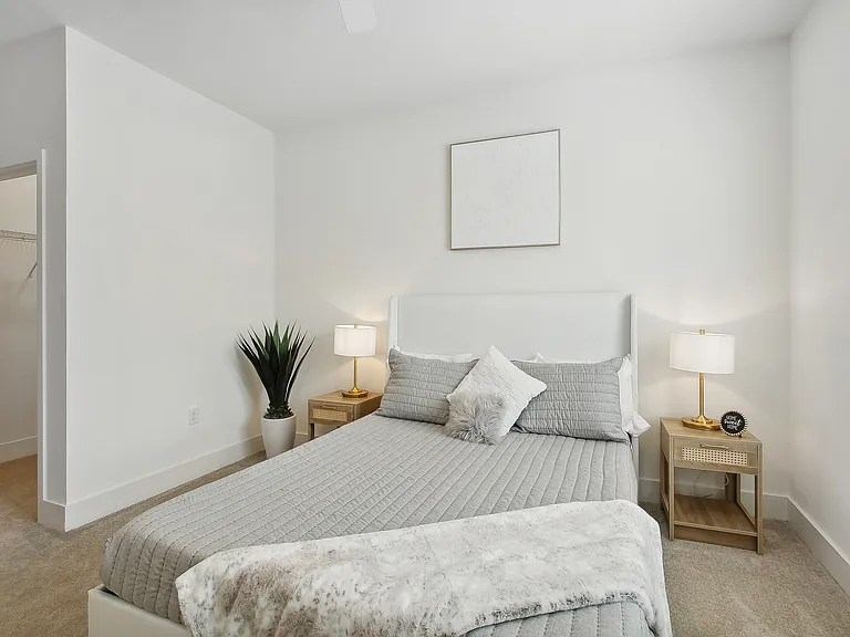Elegant bedroom with a plush gray bed, modern nightstands, and soft lighting, offering a serene and tranquil retreat.